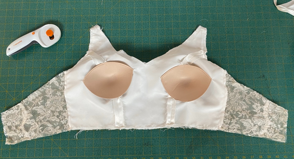 Bra cups added to the interior of the bodice between the layers of lining.